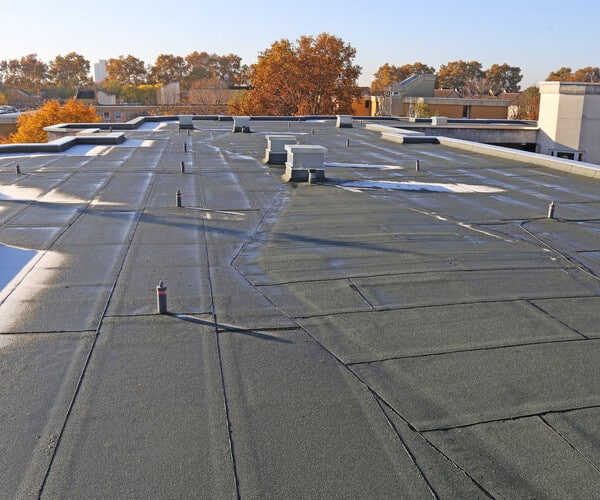 Building with newly renovated flat roof sealing