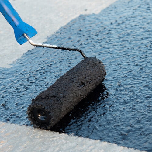 applying a coating to a flat roofing system