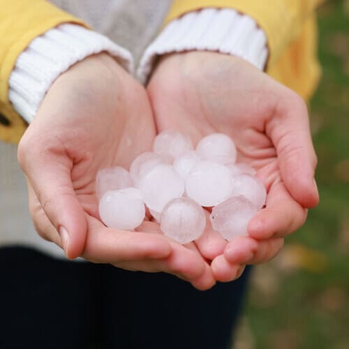 Woman holding hail after a thunderstorm outdoors, closeup
